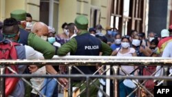 La policía controla a una multitud en fila para comprar alimentos en un mercado de La Habana. (ADALBERTO ROQUE / AFP)